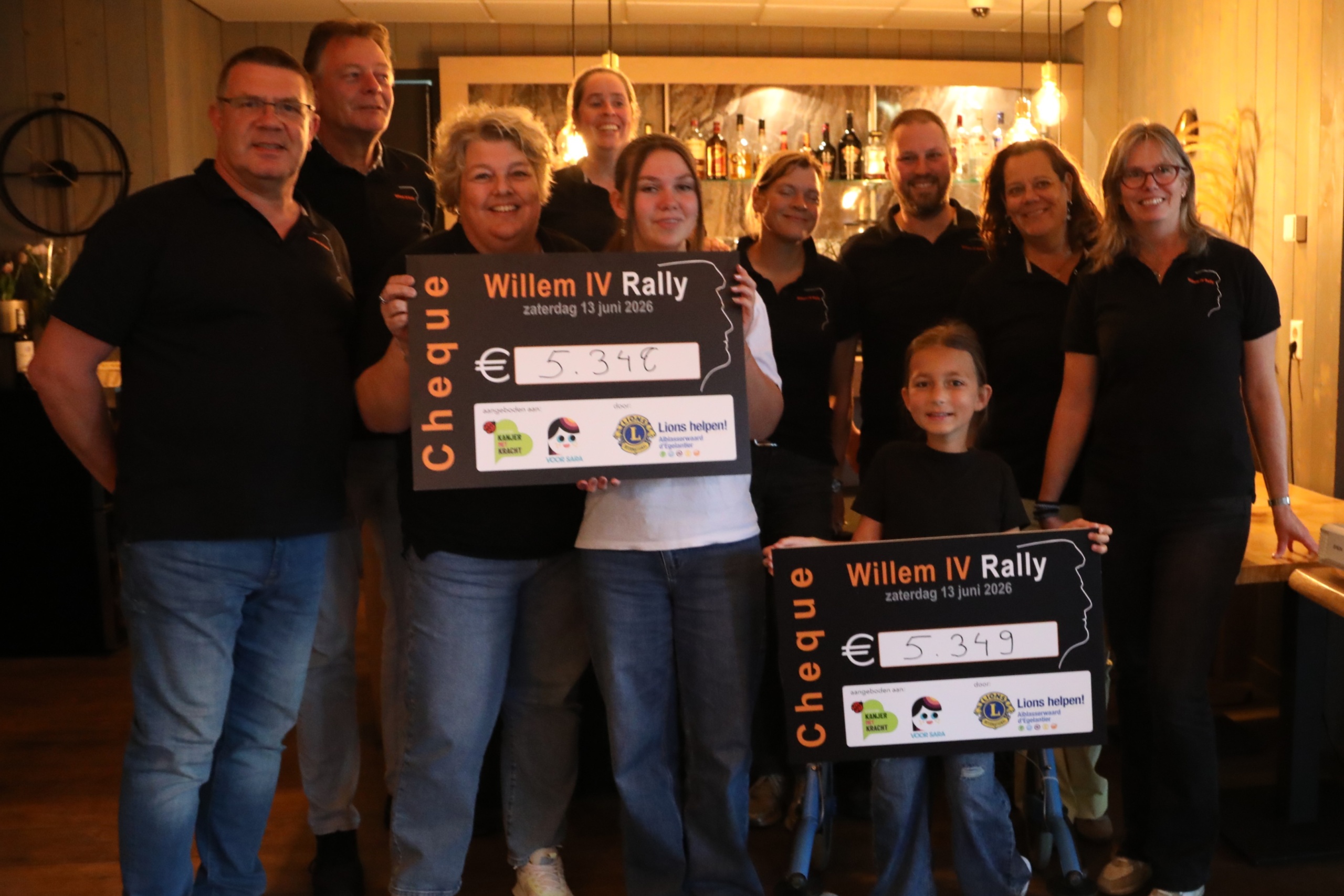 Leden van de club met twee cheques van de Willem IV Rally 2026